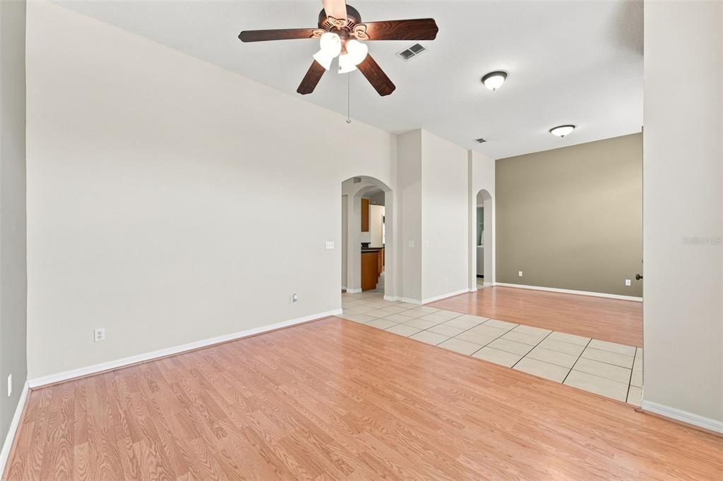 An interior view showing a living area with wood-look flooring and an adjacent tiled space — 614 RED MULBERRY DRIVE, DELTONA, FL