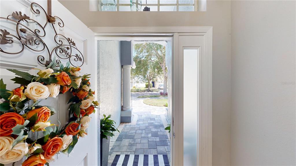 A view from an open front door looking out onto a paved walkway and driveway — 13429 FLADGATE MARK DRIVE, RIVERVIEW, FL