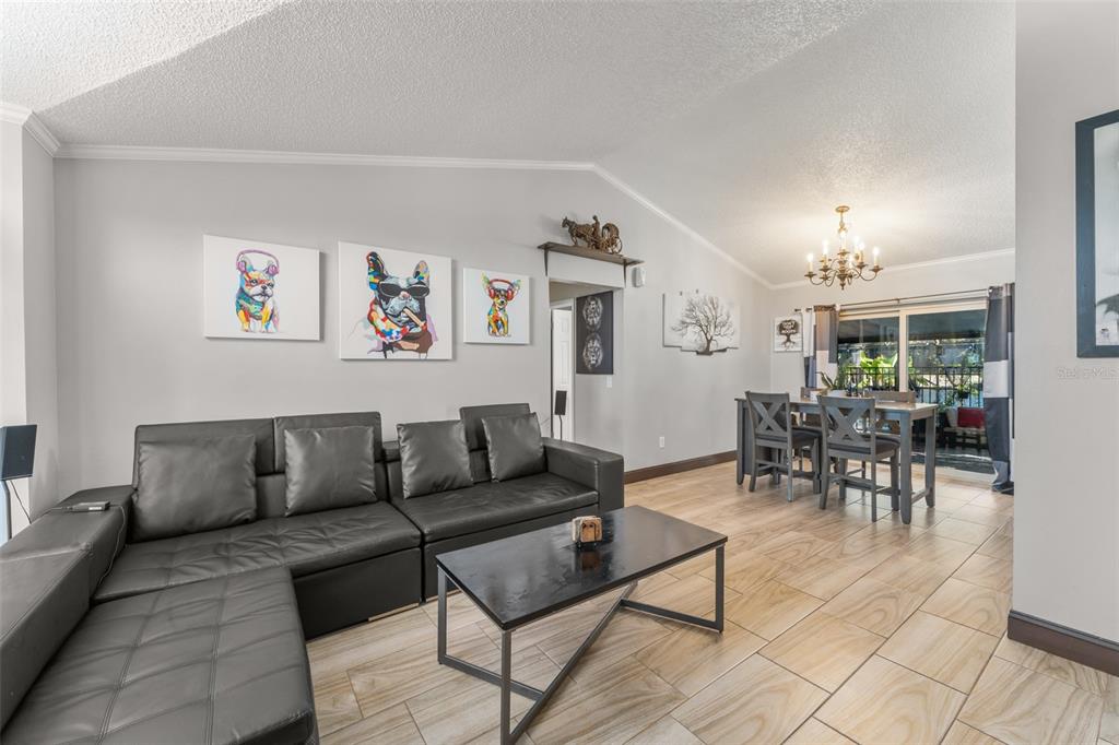 A screened-in swimming pool with a patio, lounge chair, and umbrella under a metal frame — 961 MILLENBECK AVENUE, DELTONA, FL