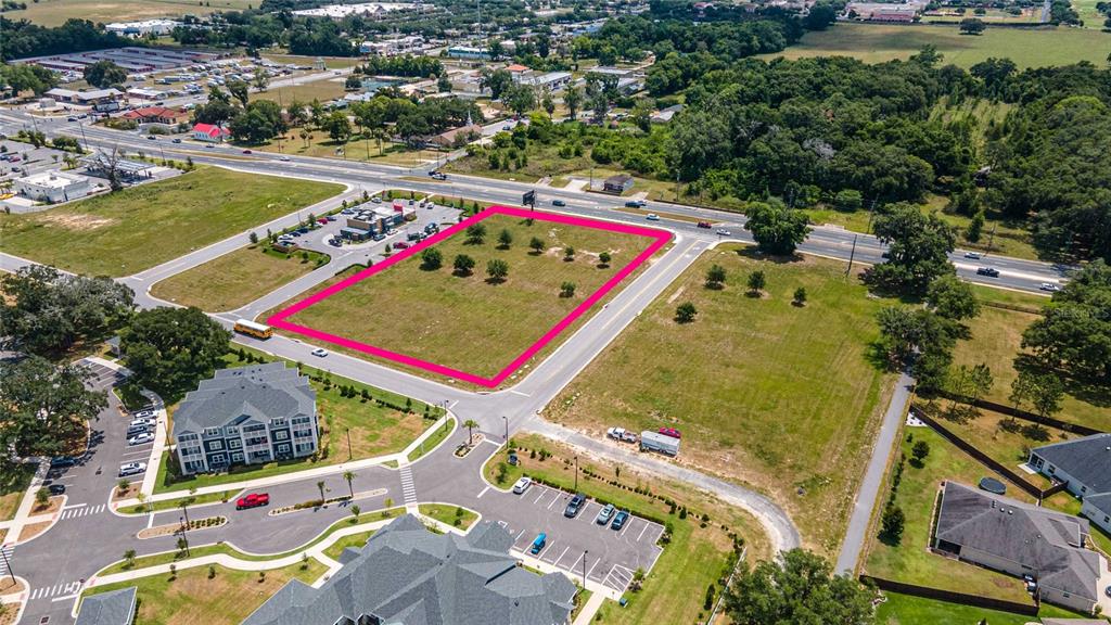 An aerial view shows a vacant rectangular lot outlined in pink near a roadway — 11532 N US HIGHWAY 301, OXFORD, FL