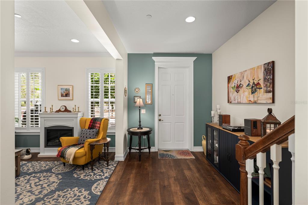 An entryway features a teal accent wall, a yellow armchair, and a dark wood cabinet — 2843 UPPER PARK ROAD, ORLANDO, FL