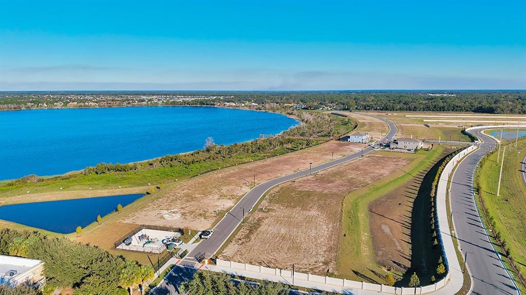 An aerial view shows a vacant residential lot next to a lake and paved roads — 19293 LOCHSIDE LANE, MOUNT DORA, FL
