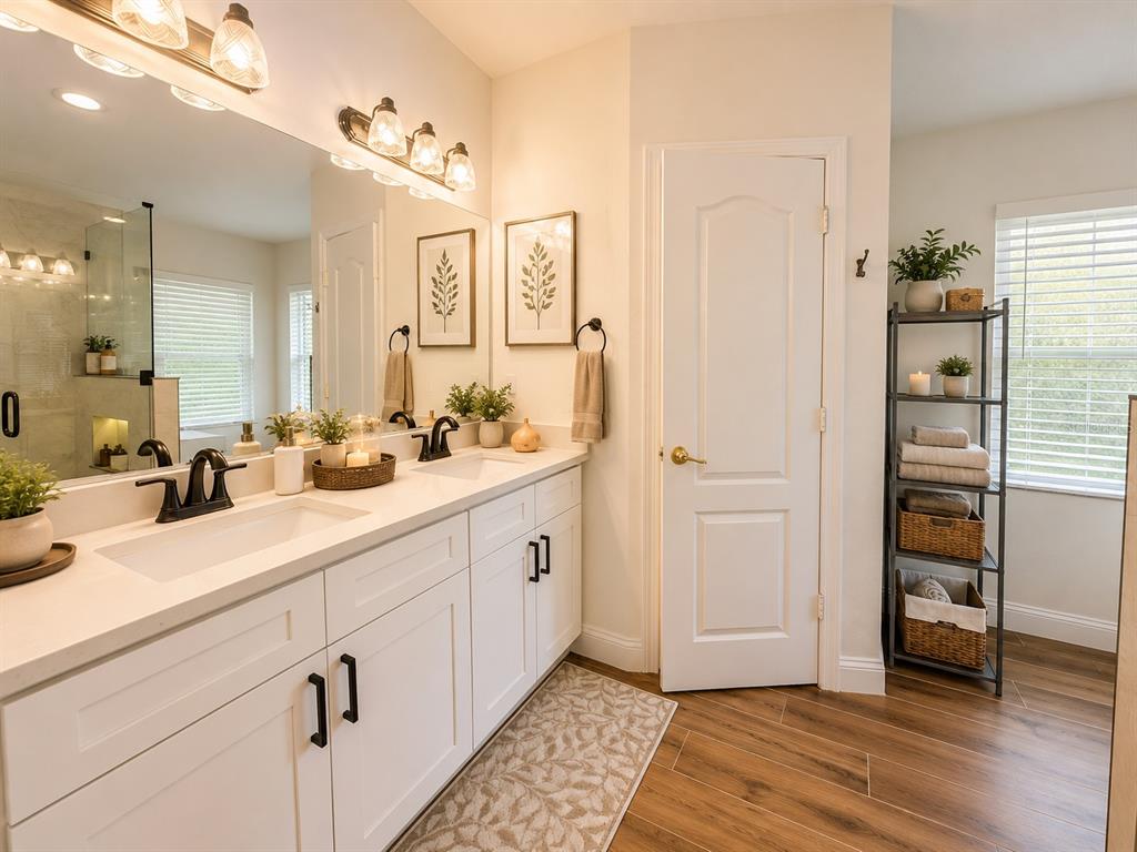 A bathroom features a double vanity with white cabinets, black hardware, and a large mirror — 25546 BRUFORD BOULEVARD, LAND O LAKES, FL