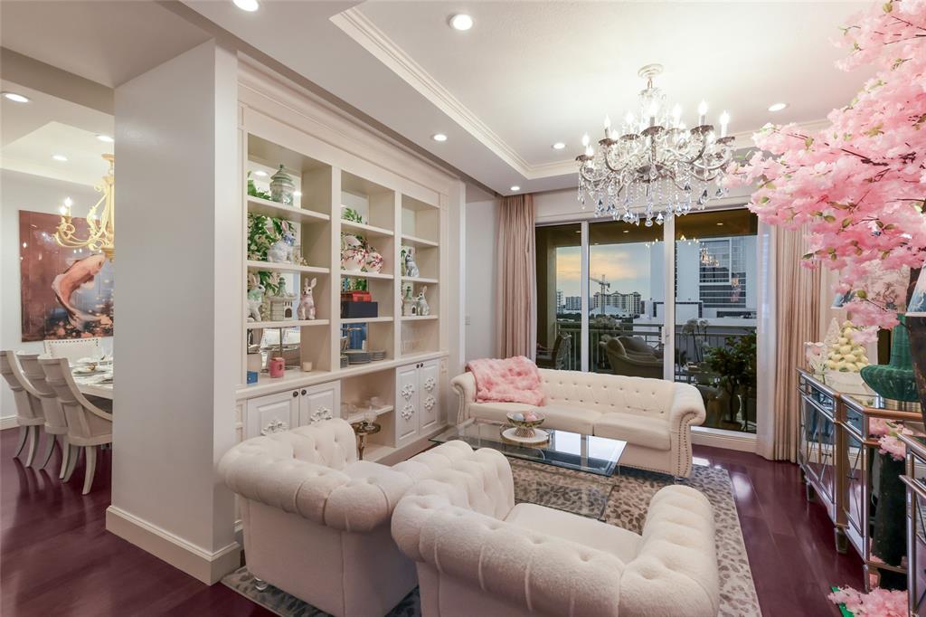 A living room with tufted white furniture, a crystal chandelier, and built-in shelving — 35 WATERGATE DRIVE UNIT 804, SARASOTA, FL