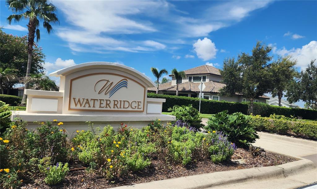 A stone monument sign for Water Ridge stands in front of a house and landscaping — 156 VALENCIA RIDGE DRIVE, AUBURNDALE, FL