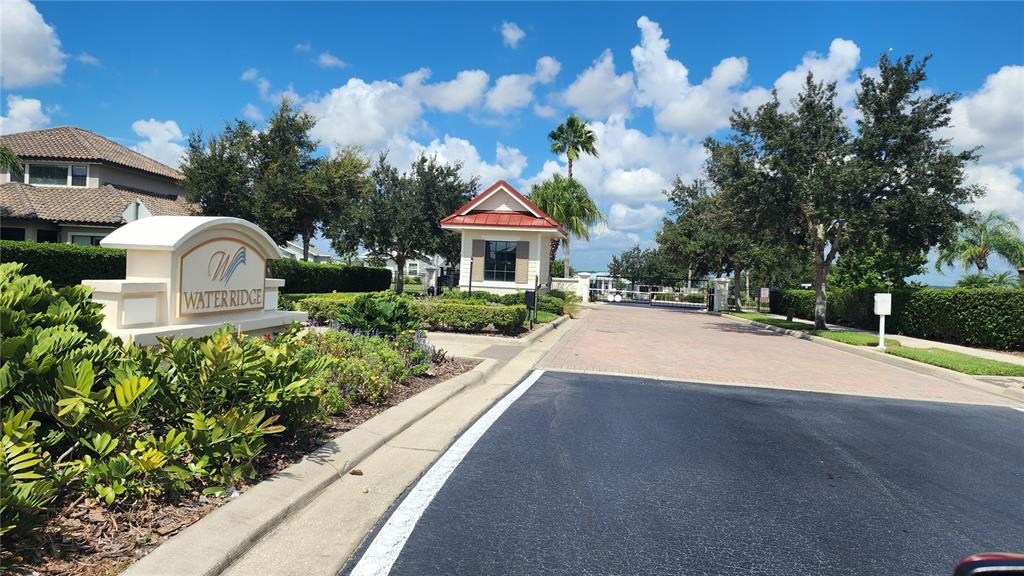 The gated entrance to the Water Ridge community features a stone sign and guardhouse — 156 VALENCIA RIDGE DRIVE, AUBURNDALE, FL