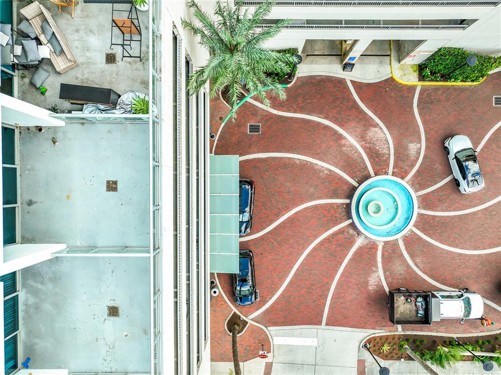 An aerial view shows a building courtyard with a circular fountain, brick driveway, and vehicles — 150 E ROBINSON STREET UNIT 617, ORLANDO, FL