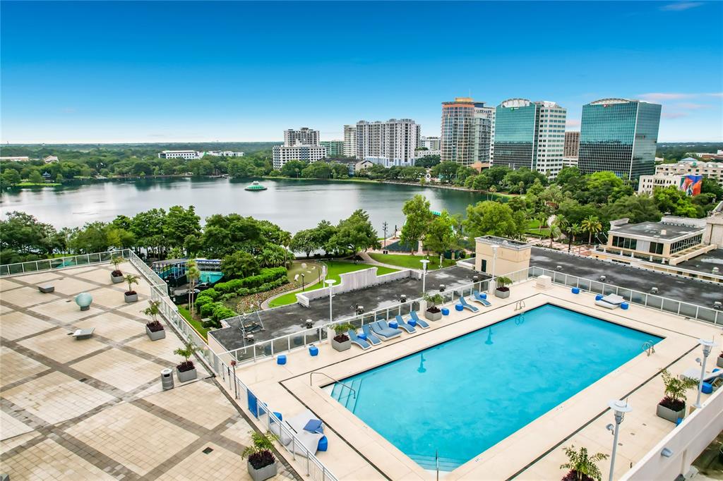 An elevated view of a rooftop swimming pool overlooking a lake and city skyline — 150 E ROBINSON STREET UNIT 617, ORLANDO, FL