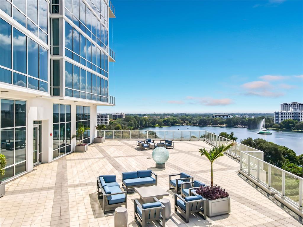 A large outdoor terrace with patio furniture and a fountain overlooking a lake — 150 E ROBINSON STREET UNIT 617, ORLANDO, FL