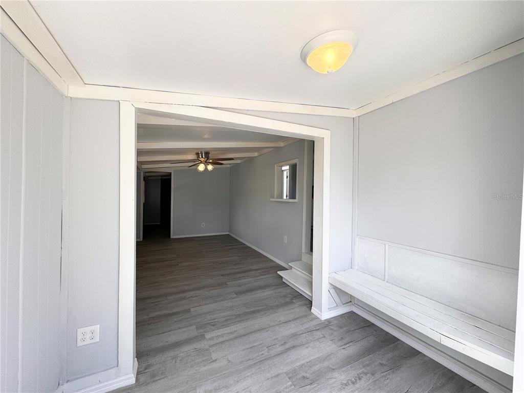 A room with light gray walls, wood-look flooring, a built-in bench, and a ceiling light — 3418 BROCKETT ROAD, MIMS, FL