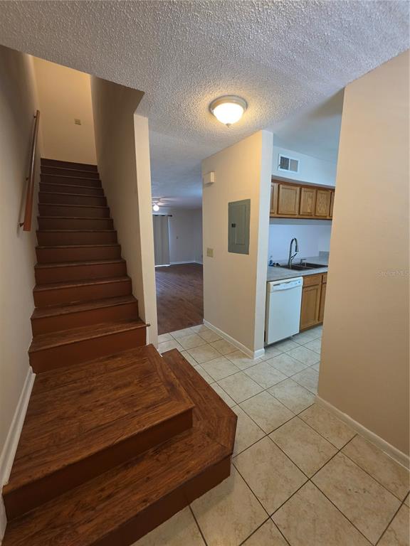 A view of a staircase with wood treads next to a kitchen with tile flooring — 5202 SUNRIDGE PALMS DRIVE UNIT 5202, TAMPA, FL