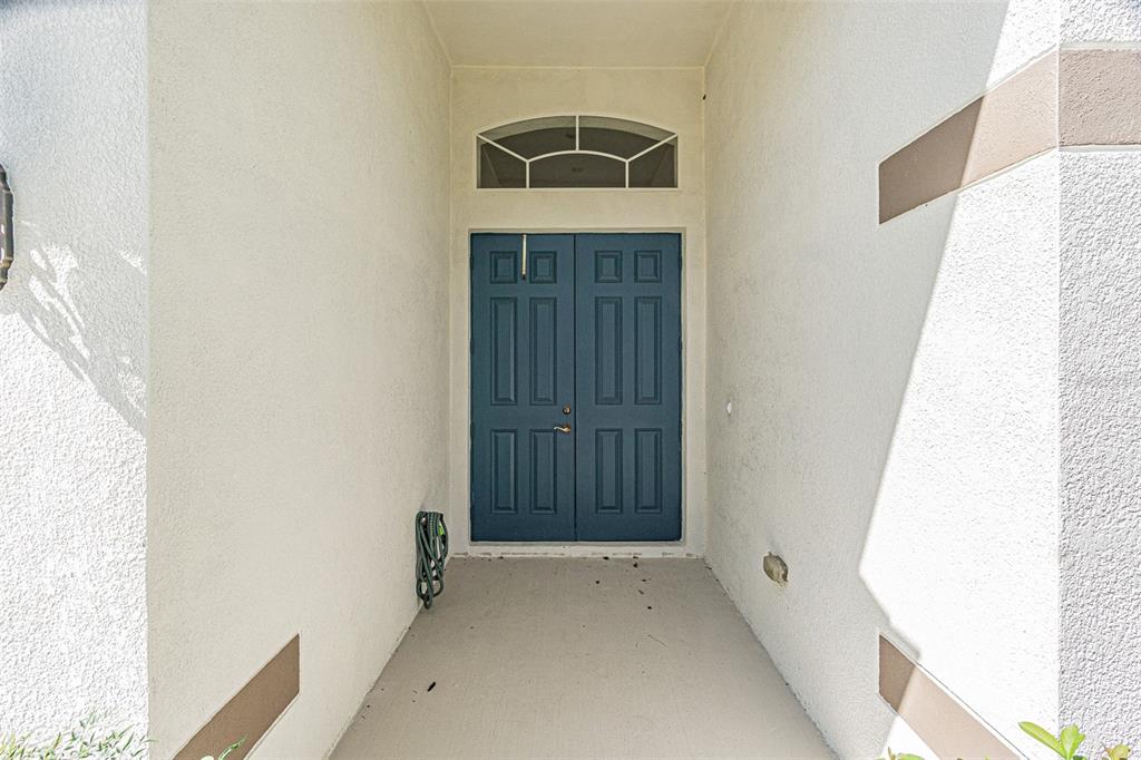 A covered entryway features a blue double door with a transom window above — 9506 ROLLING CIRCLE, SAN ANTONIO, FL