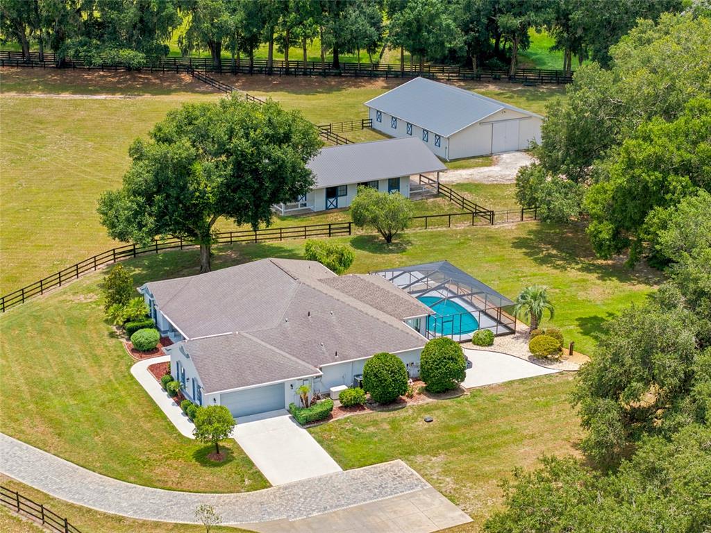 An aerial view shows a house with a pool, a barn, and fenced pastures — 16050 NW 10TH CIRCLE, CITRA, FL
