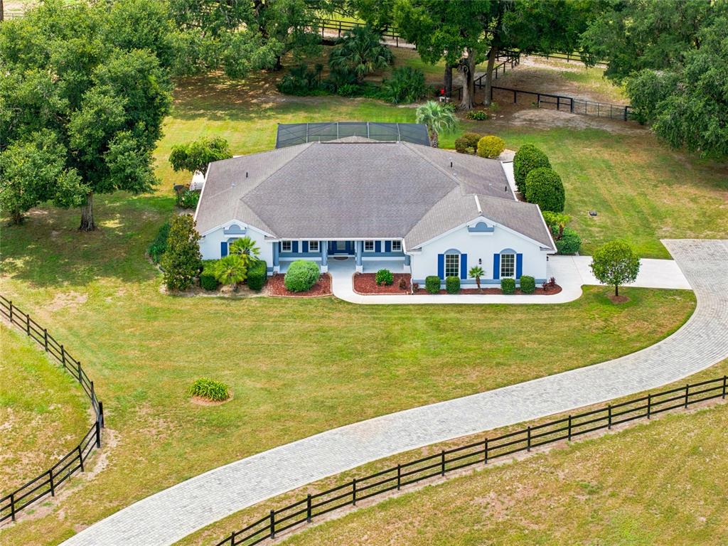 An aerial view shows a single-story house with a pool enclosure and fenced yard — 16050 NW 10TH CIRCLE, CITRA, FL