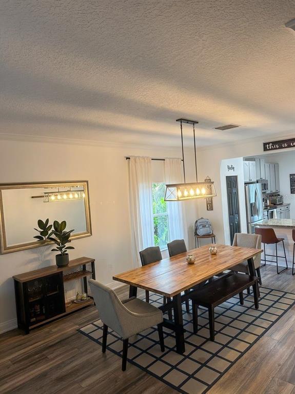 A dining room features a wooden table, chairs, a bench, and a sideboard with a mirror — 389 LAKEPARK TRAIL, OVIEDO, FL