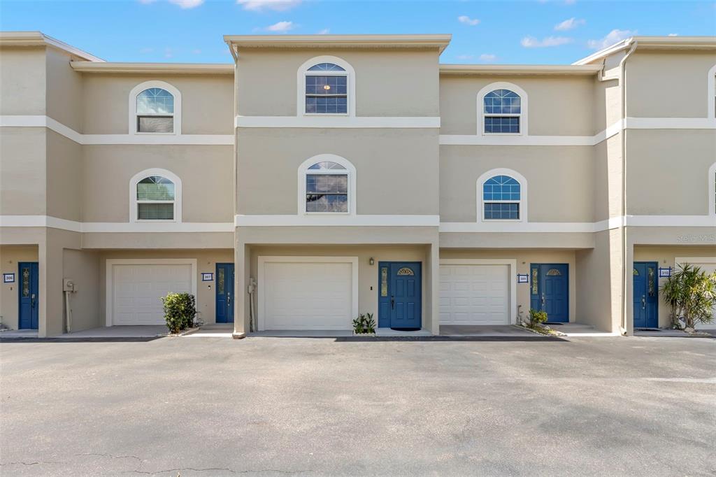 An exterior view of a multi-story apartment complex with a central pool and courtyard — 737 PINELLAS BAYWAY S UNIT 308, ST PETERSBURG, FL