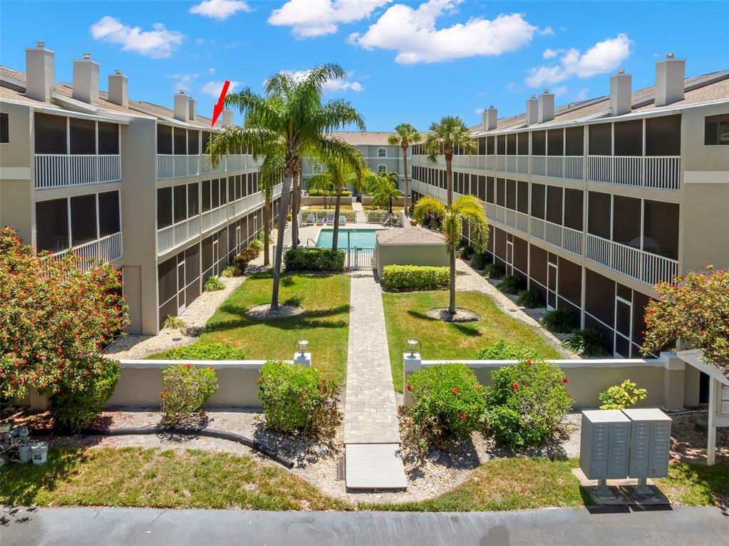 An aerial view shows a multi-story residential complex with boat slips along a canal — 737 PINELLAS BAYWAY S UNIT 308, ST PETERSBURG, FL