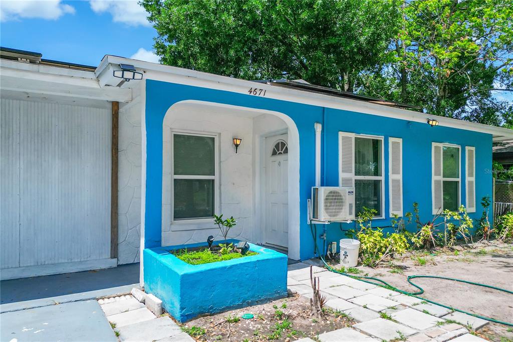 A single-story house with blue trim, a white garage door, and a gravel driveway — 4671 VERGARA COURT, ORLANDO, FL
