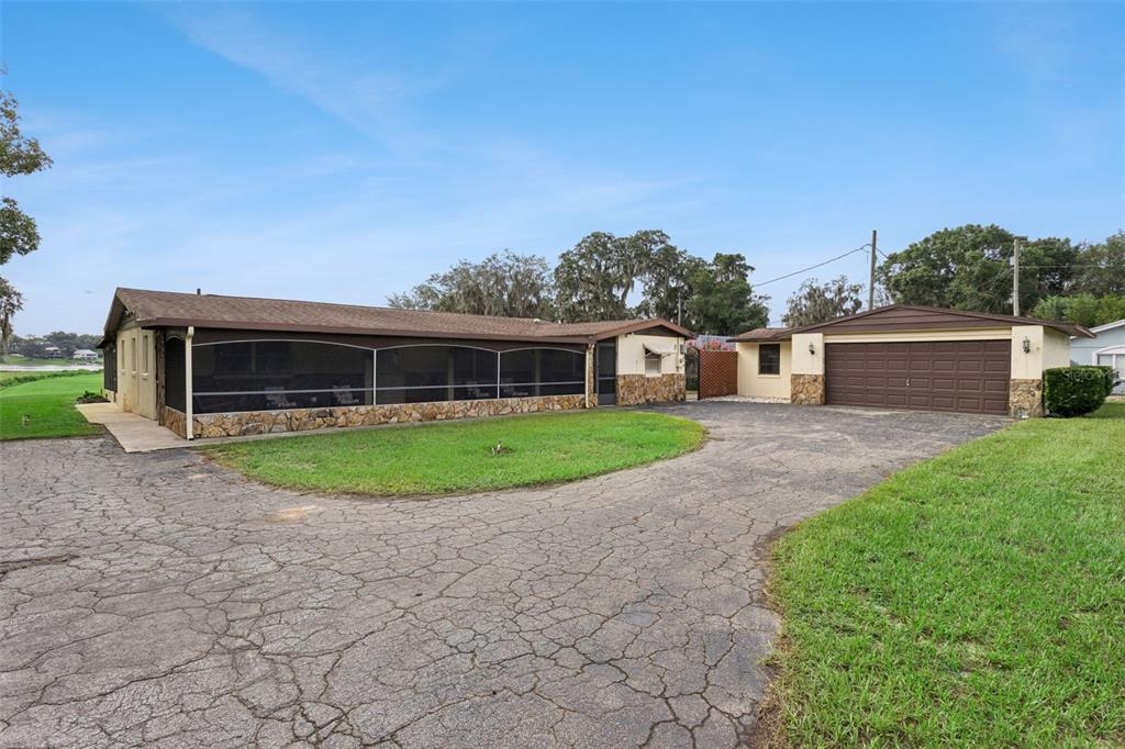 A single-story house with a screened-in porch, stone accents, and an attached two-car garage — 10617 SE 95TH TERRACE, BELLEVIEW, FL