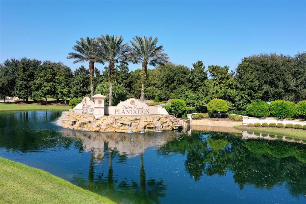 A stone monument sign for Palm Coast Plantation sits in a pond with palm trees — 34 S RIVERWALK DRIVE, PALM COAST, FL