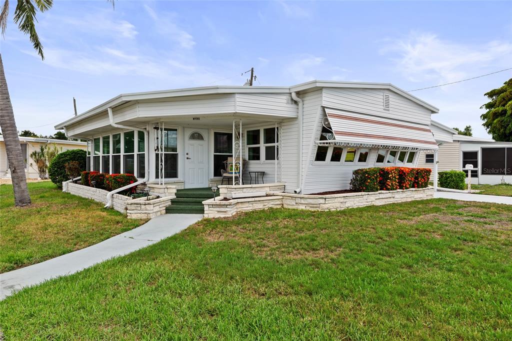 A living room with carpeted floors, a ceiling fan, and an adjacent kitchen area — 1111 42ND AVENUE E, ELLENTON, FL