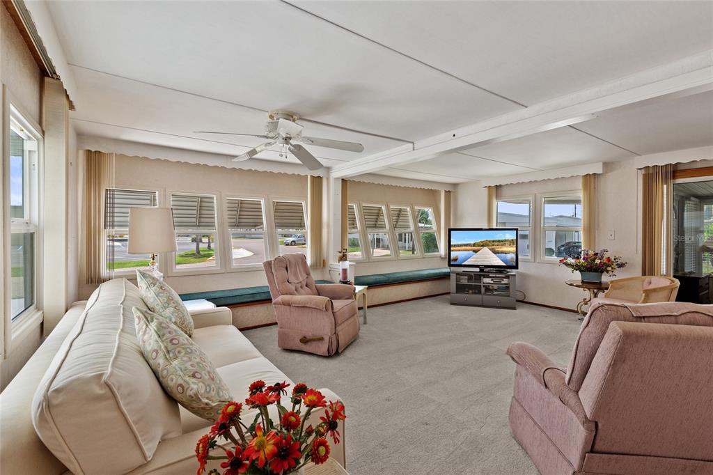 A bedroom features a bed, light wood furniture, white built-in cabinets, and a ceiling fan — 1111 42ND AVENUE E, ELLENTON, FL