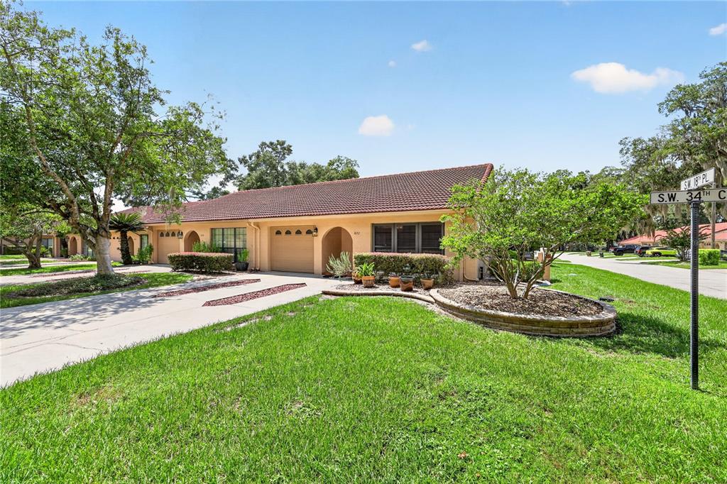 A single-story house with a tile roof, tan exterior, and a concrete driveway — 1822 SW 34TH COURT, OCALA, FL