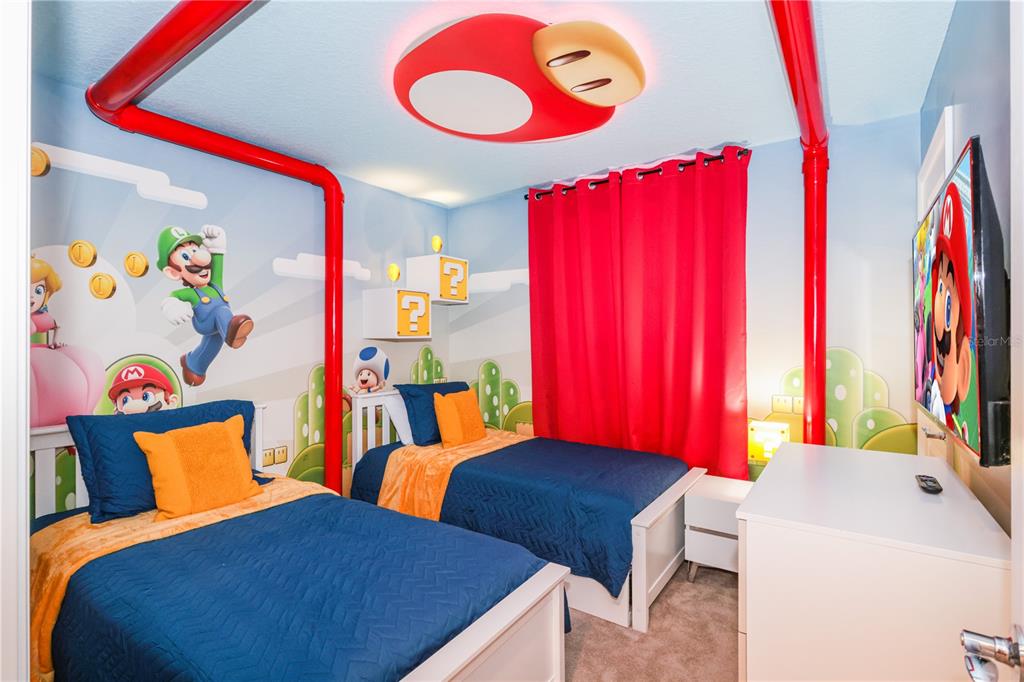 A themed bedroom features two twin beds, Mario-inspired wall murals, and a mushroom-shaped ceiling light — 227 JETTY WAY, DAVENPORT, FL