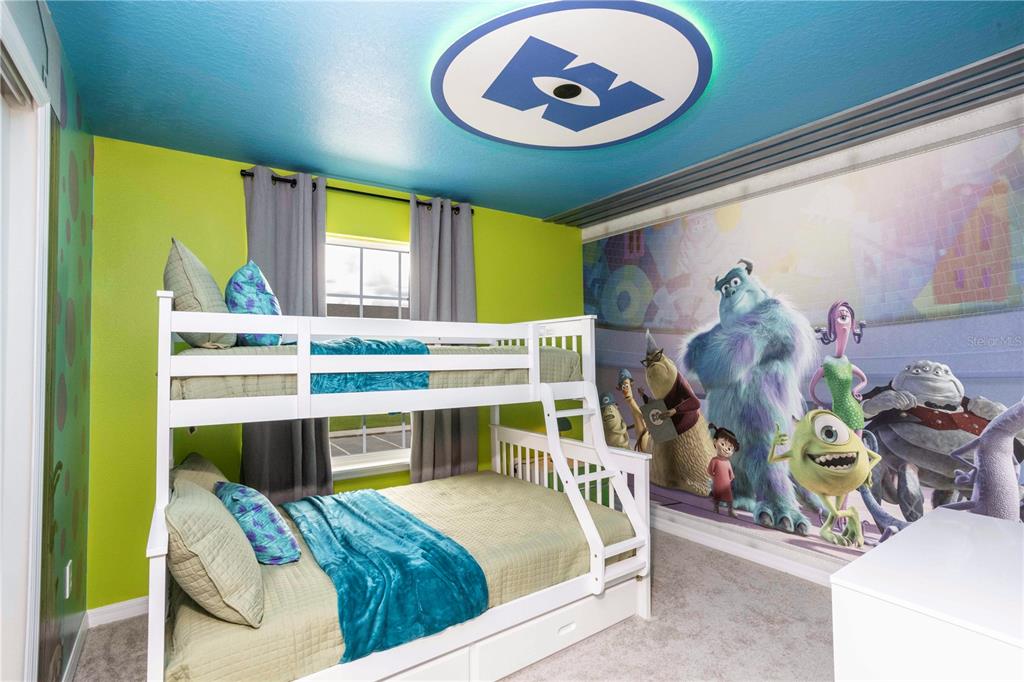 A bedroom with a bunk bed, lime green walls, and a Monsters, Inc. themed wall mural — 227 JETTY WAY, DAVENPORT, FL