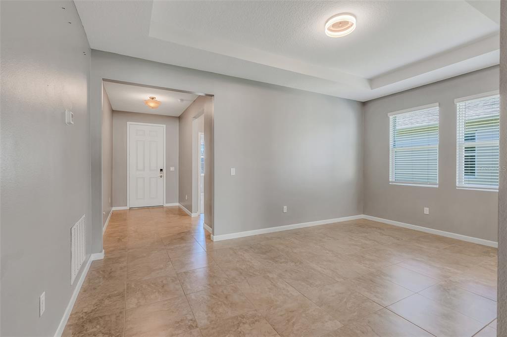 A room with light gray walls, tile flooring, a tray ceiling, and two windows — 1817 LAKE SIMS PARKWAY, OCOEE, FL