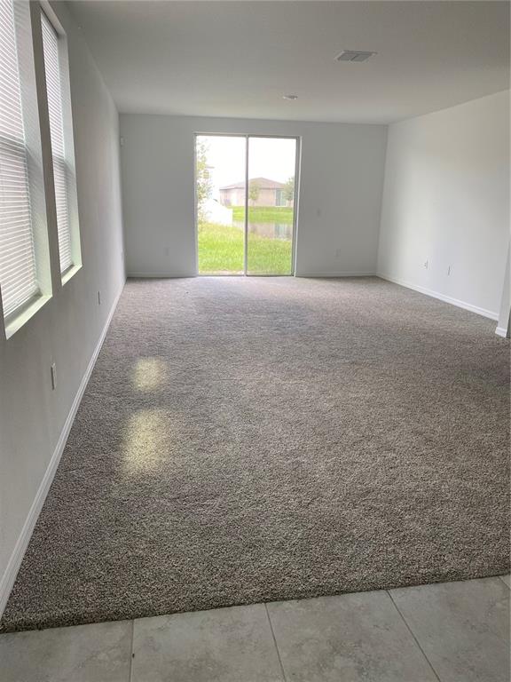 A covered entryway features a brick paver walkway leading to a dark gray front door — 3181 VICEROY COURT, KISSIMMEE, FL