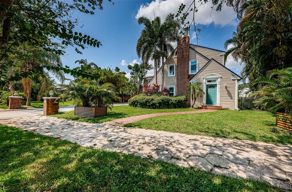 A two-story house with beige siding, a brick chimney, and a stone walkway — 3730 FOSTER HILL DRIVE N, ST PETERSBURG, FL