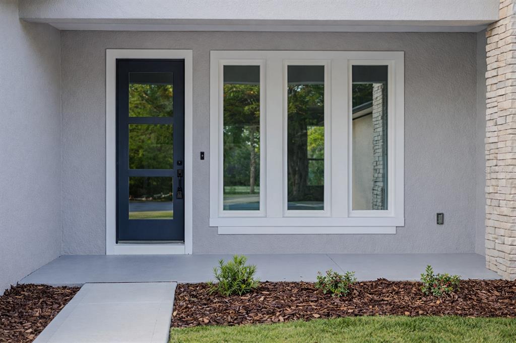 A single-story house with a light gray stucco exterior, dark shutters, and a front walkway — 45 ROYAL OAK DRIVE, PALM COAST, FL