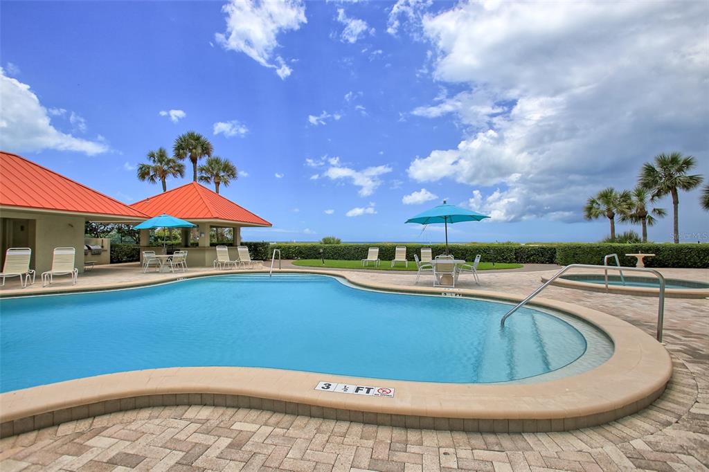 A balcony with patio furniture overlooks a sandy beach and the ocean — 1290 GULF BOULEVARD UNIT 1002, CLEARWATER, FL