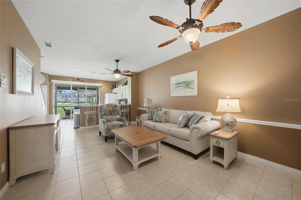 A living room with tile floors, a beige sofa, a coffee table, and a ceiling fan — 2330 FELICITY PLACE, NORTH PORT, FL