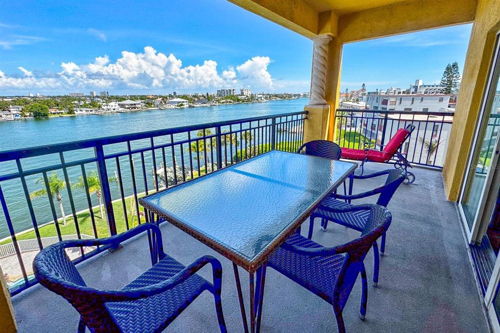 A multi-story yellow stucco building with arched balconies and a covered parking entrance — 10315 GULF BOULEVARD UNIT 409, TREASURE ISLAND, FL