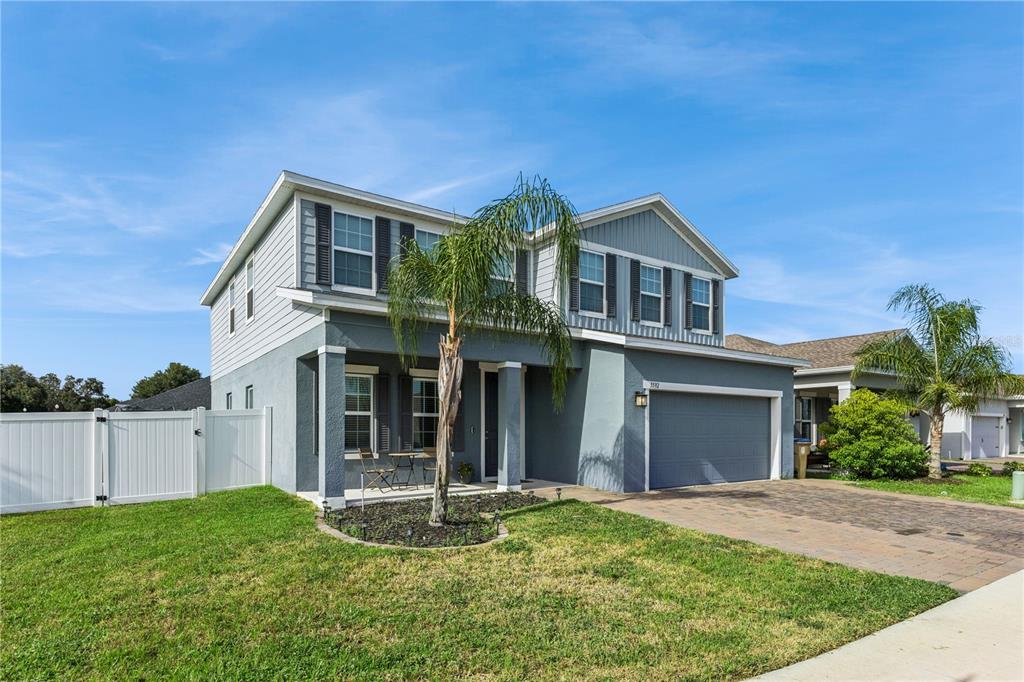 A two-story house with a gray exterior, a two-car garage, and a palm tree — 5592 VIGO LOOP, ST CLOUD, FL