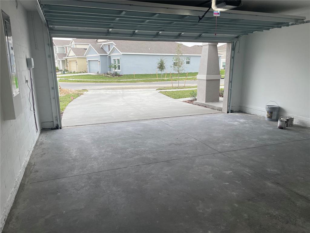 An empty residential garage with a concrete floor and an open door facing a street — 612 DARING DRIVE, DAVENPORT, FL