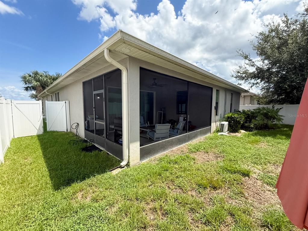 A screened-in patio is attached to the side of a house with a grassy yard — 2524 FONTAINE DRIVE, KISSIMMEE, FL
