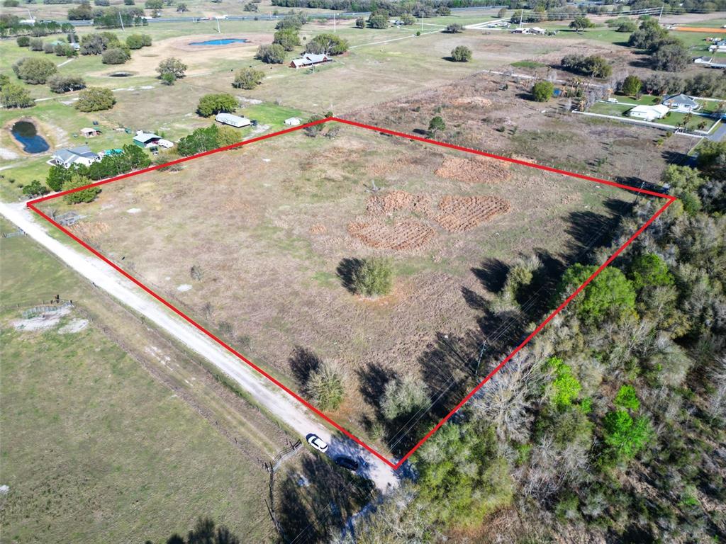 An aerial view shows a large, rectangular plot of vacant land outlined in red — 000000- CR 614A, BUSHNELL, FL