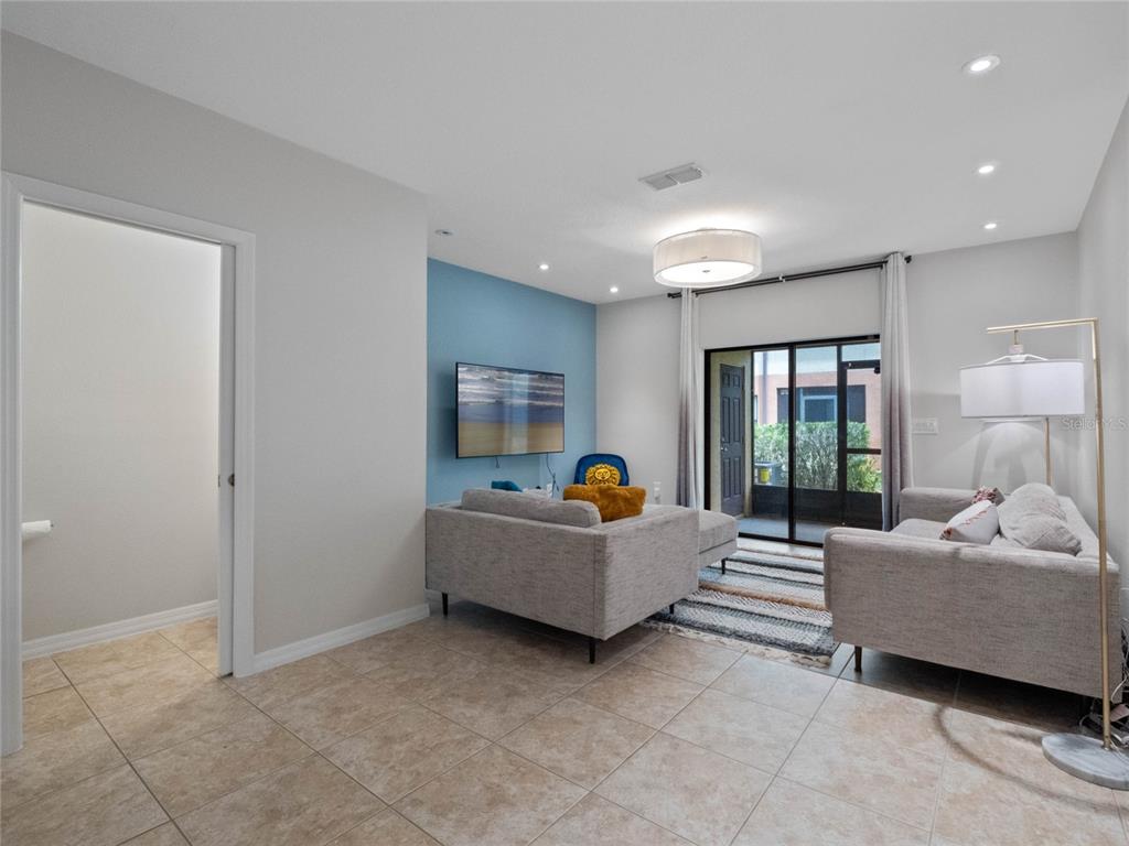 A living room features light tile floors, a blue accent wall, and a sliding glass door — 2240 TRILLIUM PARK LANE, SANFORD, FL
