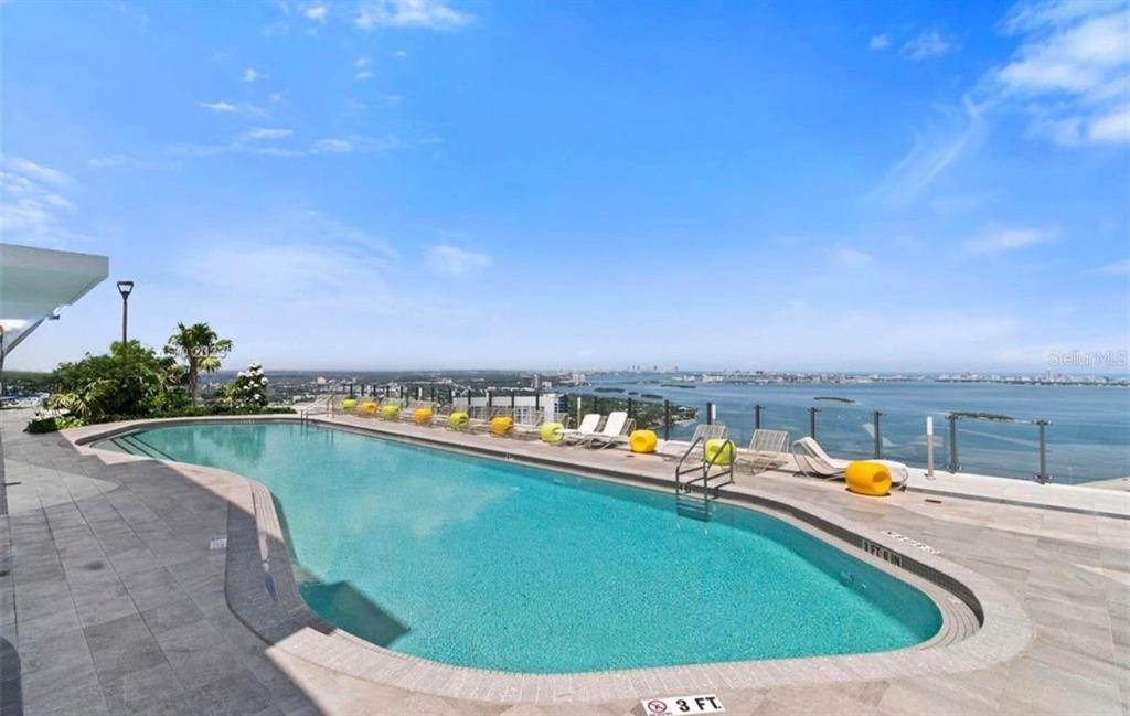 An outdoor swimming pool on a high-rise terrace overlooks a bay and city skyline — 501 NE 31ST STREET UNIT 1808, MIAMI, FL