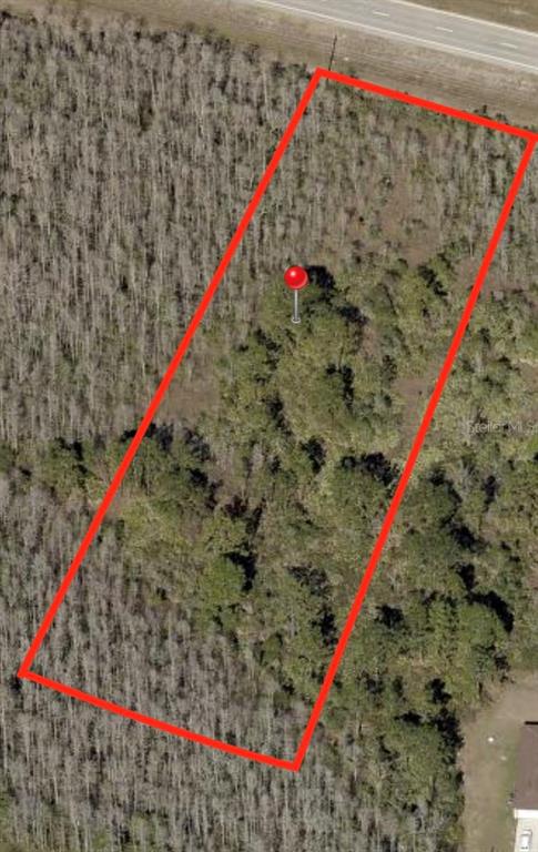 An aerial view shows a rectangular plot of wooded land outlined in red — 0 E IRLO BRONSON MEMORIAL HIGHWAY, ST CLOUD, FL