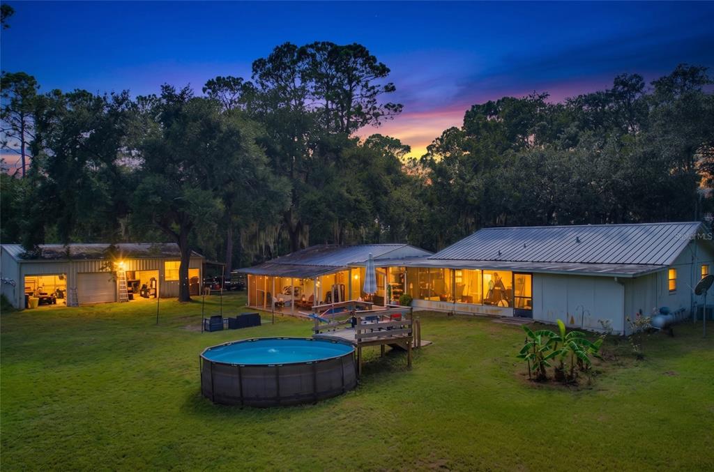 An exterior view of a house and detached garage with a pool in the backyard — 10930 CAMP MACK ROAD, LAKE WALES, FL