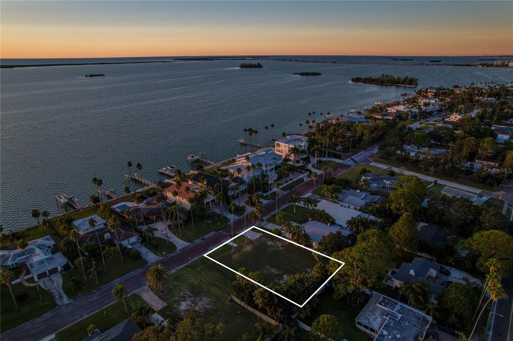 An aerial view shows a vacant rectangular lot outlined in white near a coastal neighborhood — 1645 SANTA BARBARA DRIVE, DUNEDIN, FL