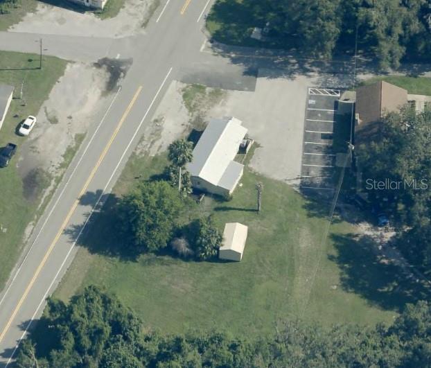 An aerial view shows a building, a small shed, and a parking lot near a road — 821 S US 301, SUMTERVILLE, FL