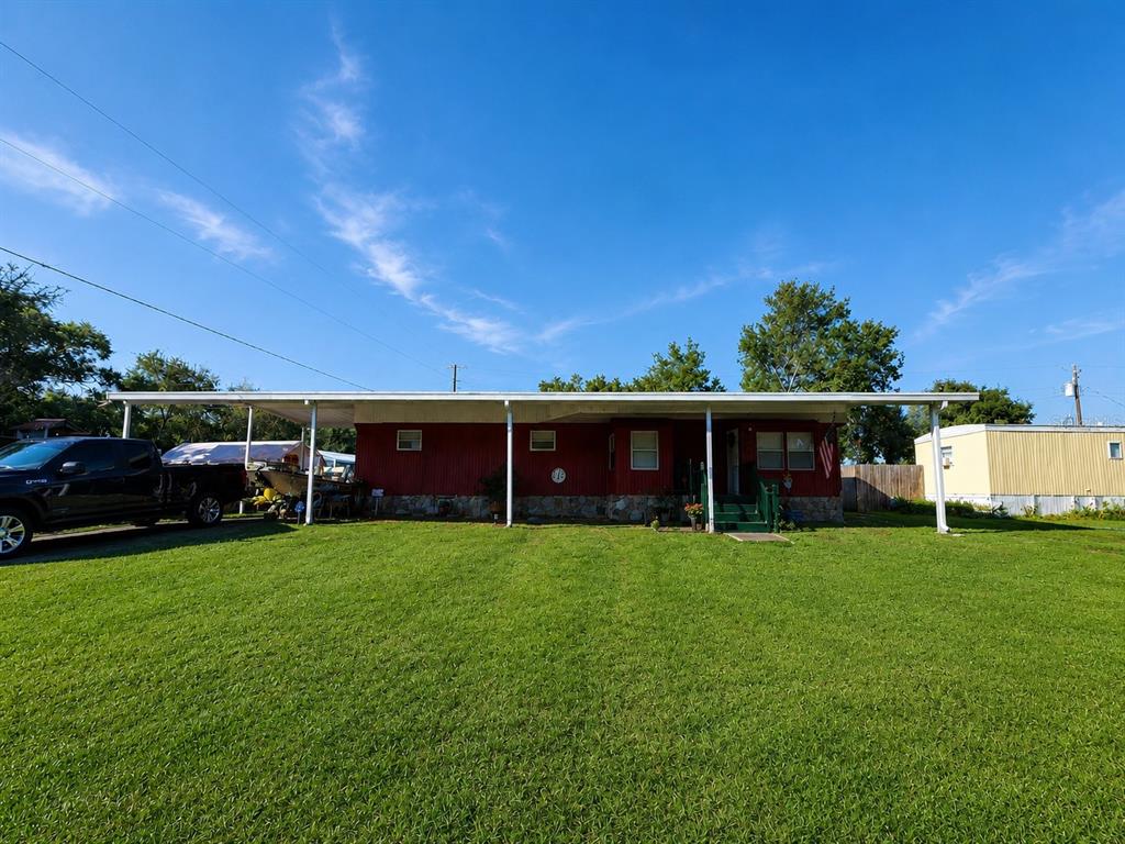 A red single-story manufactured home with a covered porch sits on a grassy lot — 3074 LARKIN ROAD, MIMS, FL