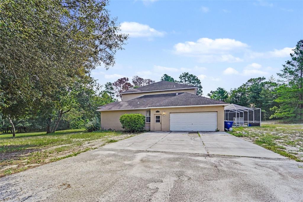 A two-story house with a concrete driveway, a two-car garage, and a screened-in pool enclosure — 10724 PATRICK AVE, HUDSON, FL