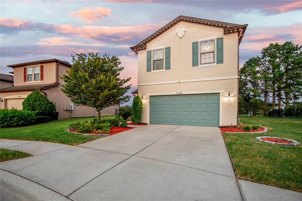 A two-story house with a beige stucco exterior, green shutters, and a two-car garage — 4346 O ROURKE COURT, WESLEY CHAPEL, FL