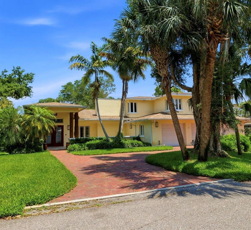 A two-story yellow house with a brick driveway and palm trees in the front yard — 6000 2ND STREET S, ST PETERSBURG, FL